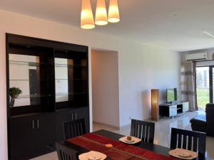 a dining room and living room with a table and chairs at Le Meritt Appartments in Quatre Bornes