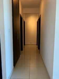 a hallway of a building with black doors and tile floors at Le Meritt Appartments in Quatre Bornes +1 photo