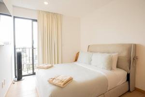 a bedroom with a white bed with a large window at Luxury 2BR with Pool, Gym & Coworking in Mexico City +42 photos