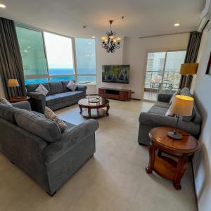 ein Wohnzimmer mit Sofas und einem Tisch in der Unterkunft Trio Sea View شقة تريو البحرية in Dschidda