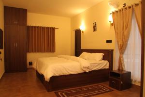 een slaapkamer met een groot bed met witte lakens bij Luxurious Private Vantage Villa - Kotagiri in Kotagiri