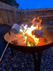 a fire pit with two utensils around it at Mill House Farm Pods- Jackdaws Den in Pilling +6 photos