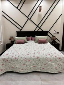 een groot bed met roze kussens in een slaapkamer bij Rana Villa's & Rest Stop in Lahore
