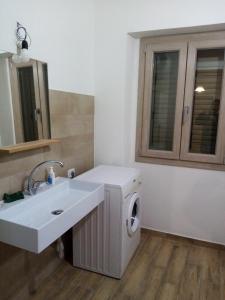 een badkamer met wastafel en wasmachine bij Enjoy The Silence Flat in Orosei