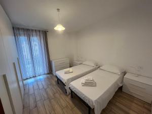 een slaapkamer met 2 aparte bedden en een raam bij Enjoy The Silence Flat in Orosei