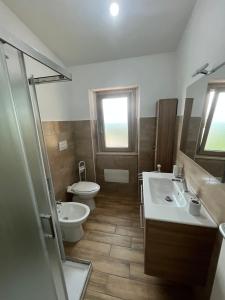 een badkamer met een toilet, een wastafel en een douche bij Enjoy The Silence Flat in Orosei