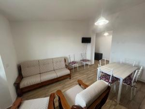 een woonkamer met een bank, een tafel en stoelen bij Enjoy The Silence Flat in Orosei