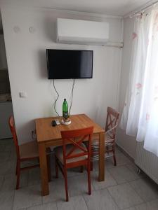 a table with chairs and a television on a wall at PAR in Donje Mladice