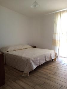 een slaapkamer met een bed en een raam bij Cozy And Cool Flat in Orosei