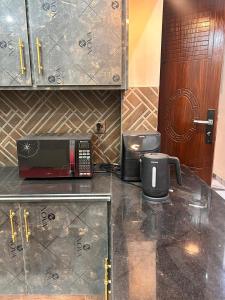 een keuken met een magnetron en een koffiezetapparaat op een aanrecht bij Rana Villa's & Rest Stop in Lahore