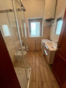 een badkamer met een douche, een toilet en een wastafel bij Cozy And Cool Flat in Orosei +3 foto's