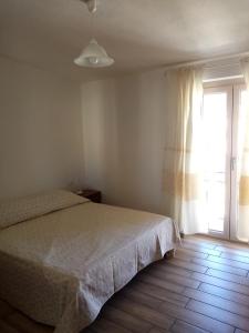 een slaapkamer met een bed en een groot raam bij Cozy And Cool Flat in Orosei
