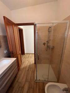 een badkamer met een douche, een toilet en een wastafel bij Cozy And Cool Flat in Orosei