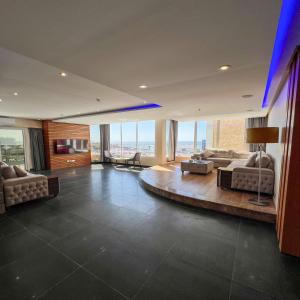 ein großes Wohnzimmer mit Sofas und ein Zimmer mit Fenstern in der Unterkunft Trio Sea View شقة تريو البحرية in Dschidda