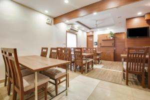 ein Esszimmer mit Tischen und Stühlen und einem Flachbildfernseher in der Unterkunft Hotel Arjun Near Sector 20 Panchkula in Rāmgarh