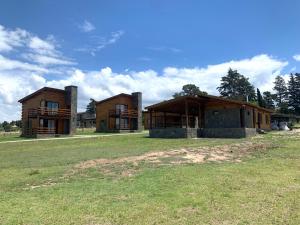two buildings on a grass field with a sky at San Yucac Relax in Los Reartes