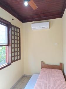 een slaapkamer met een bed, een plafondventilator en een raam bij Casa 4 Quartos 2 Quadras da Praia Com Roupa Cama in Porto Seguro