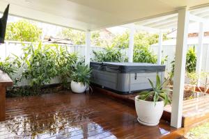 a hot tub on a porch with potted plants at Studio11 - Vincentia in Vincentia
