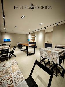 ein Raum mit Tischen und Stühlen und einem Hotel-Honda-Schild in der Unterkunft Hotel Flórida Poços in Poços de Caldas