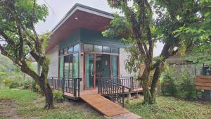 una piccola casa con portico e terrazza di Mama Home Misty Lakeside a Pong