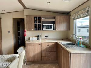 eine kleine Küche mit Spüle und Mikrowelle in der Unterkunft Lake Front 2 Bed Caravan, South Cerney in Cirencester