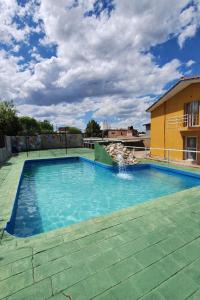 ein Schwimmbecken mit einem Springbrunnen in der Mitte in der Unterkunft KIN Hotel in Villa Carlos Paz