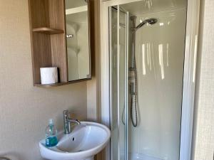 ein Badezimmer mit Waschbecken und Dusche in der Unterkunft Lake Front 2 Bed Caravan, South Cerney in Cirencester + 7 Fotos