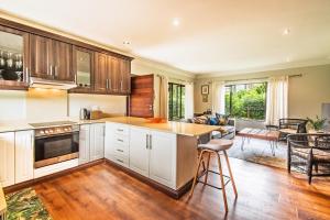 een keuken met witte kasten en een tafel en stoelen bij Robyns Nest Self Catering Cottage No4 in Gillitts +18 foto's