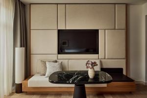 een kamer met een bed met een tafel en een televisie bij The Florentin by Althoff Collection in Frankfurt am Main