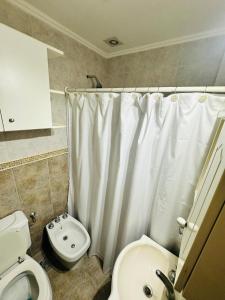 bagno con tenda da doccia bianca e servizi igienici di Recreo a Necochea