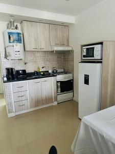 una cucina con mobili in legno e un frigorifero bianco di Recreo a Necochea