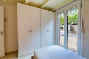 a bedroom with white cabinets and a window at Lenika Residence in Sísai