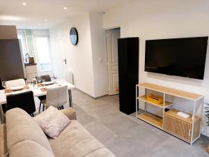 a living room with a couch and a large flat screen tv at The Calais Beacon in Calais