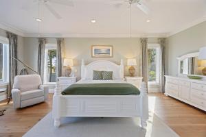 una camera da letto bianca con un letto bianco e una sedia di OP58: 58 Ocean Point a Isle of Palms Altre 49 foto