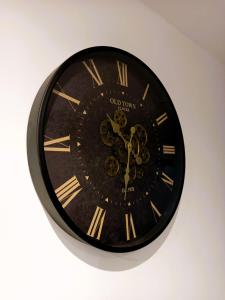 eine schwarze Uhr mit römischen Zahlen an der Wand in der Unterkunft The Calais Beacon in Calais