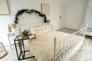 a bedroom with a white bed with a white headboard at Willa Aleksandria in Konopiska