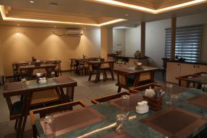 an empty restaurant with wooden tables and chairs at Sasya Elegance - A Boutique Hotel in Lingampalli
