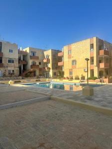 een zwembad op een parkeerplaats naast gebouwen bij SeaView Escape with Pool Access in St Paul's Bay