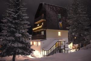 ein großes Gebäude im Schnee bei Nacht in der Unterkunft Apartments Mont Jahorina in Jahorina