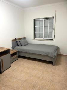 una camera da letto con un letto e una finestra di Apartamento Serena a Vila Real de Santo António