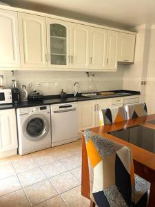 una cucina con mobili bianchi e lavatrice di Apartamento Serena a Vila Real de Santo António