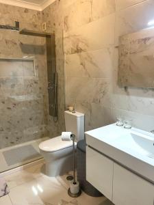 un bagno con wc, lavandino e doccia di Apartamento Serena a Vila Real de Santo António