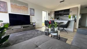 a living room with a couch and a tv and a table at FeWo-Brombachseeblick in Absberg