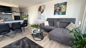 a living room with a gray couch and a table at FeWo-Brombachseeblick in Absberg