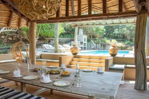 a wooden table with plates of food on top of it at Monarch Beach Villa in Cimbene +20 photos