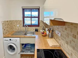 a kitchen with a sink and a washing machine at Hindscarth in Keswick