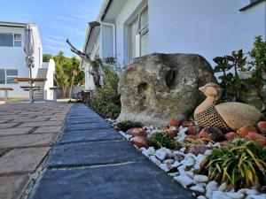een tuin met twee eenden die op een rots zitten bij Southeaster in Bloubergstrand