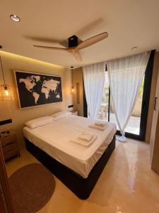 a bedroom with a large bed with a ceiling fan at Apartamentos Flores playa in La Mata