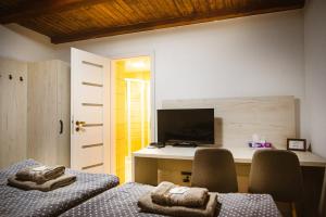 Zimmer mit 2 Stühlen und einem Schreibtisch mit einem TV in der Unterkunft Penzión Pri Kaštieli Záturčie in Martin