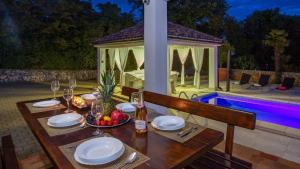 een tafel met borden en wijnglazen bovenop bij Vila Gostinjac 2 with pool Krk by Villas Guide in Gostinjac